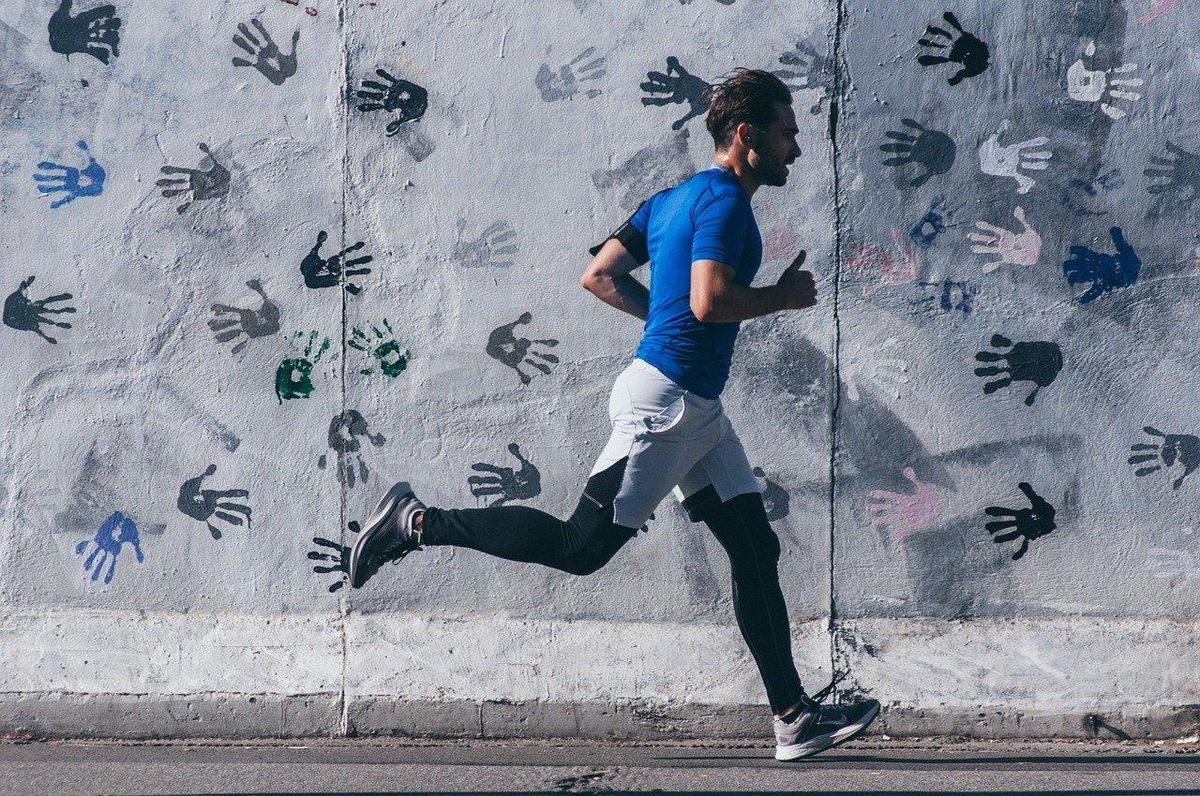 Un coureur file le long d'un mur inspirant, chaque pas un souffle de vitalité.