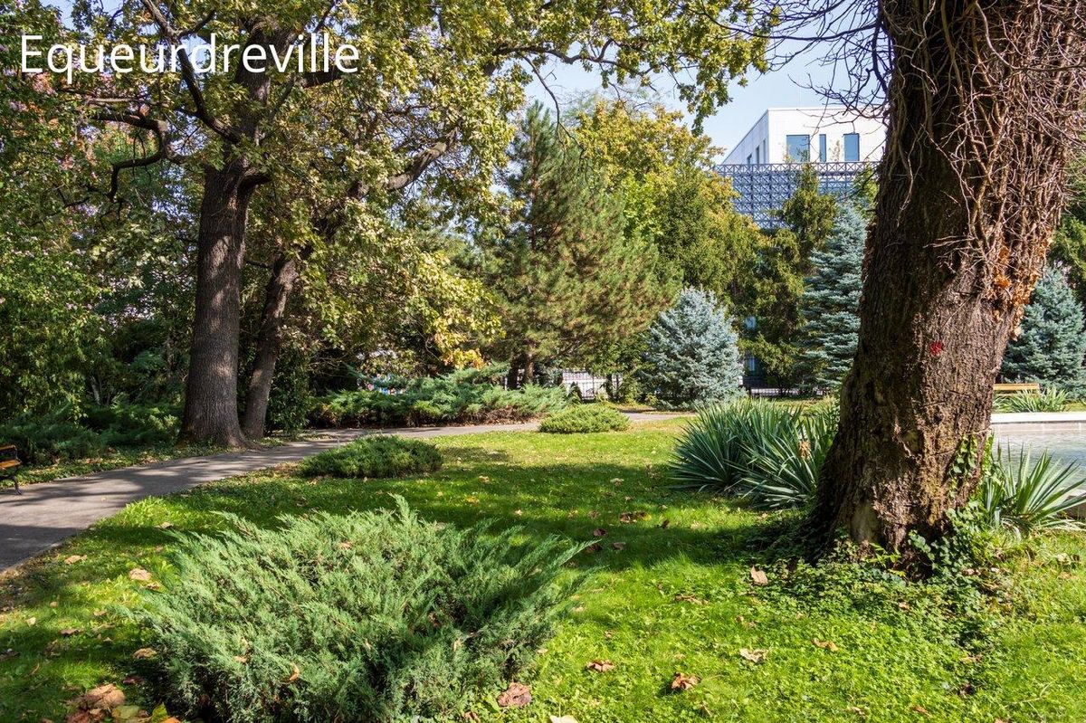 Verdure luxuriante entourant un bâtiment moderne au cœur du jardin du Radiophare.